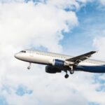 Avião branco e azul em céu com nuvens