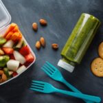 Comidas, suco verde e garfos