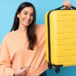 Mulher carregando e apontando para mala de viagem